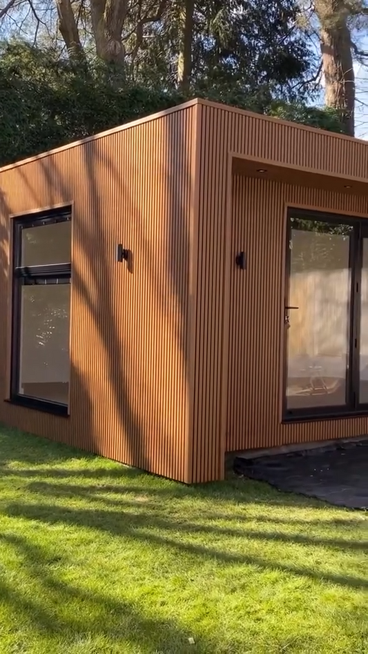 Casa modular de jardín revestida completamente con listones WPC exterior color madera, ventanas negras y puerta de vidrio.