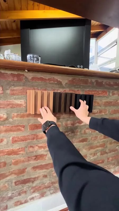 Instalación de paneles WPC listonados sobre pared de ladrillo