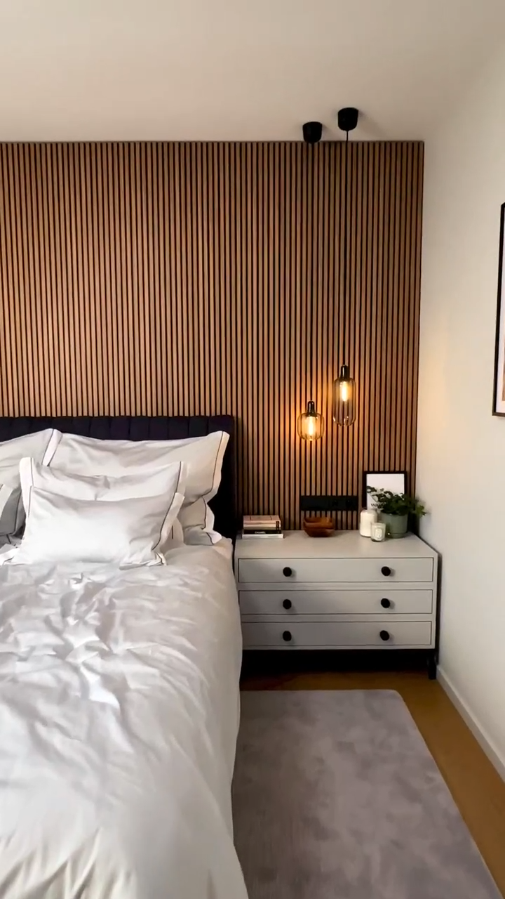 Revestimiento WPC listonado en pared de cama con lámparas colgantes
